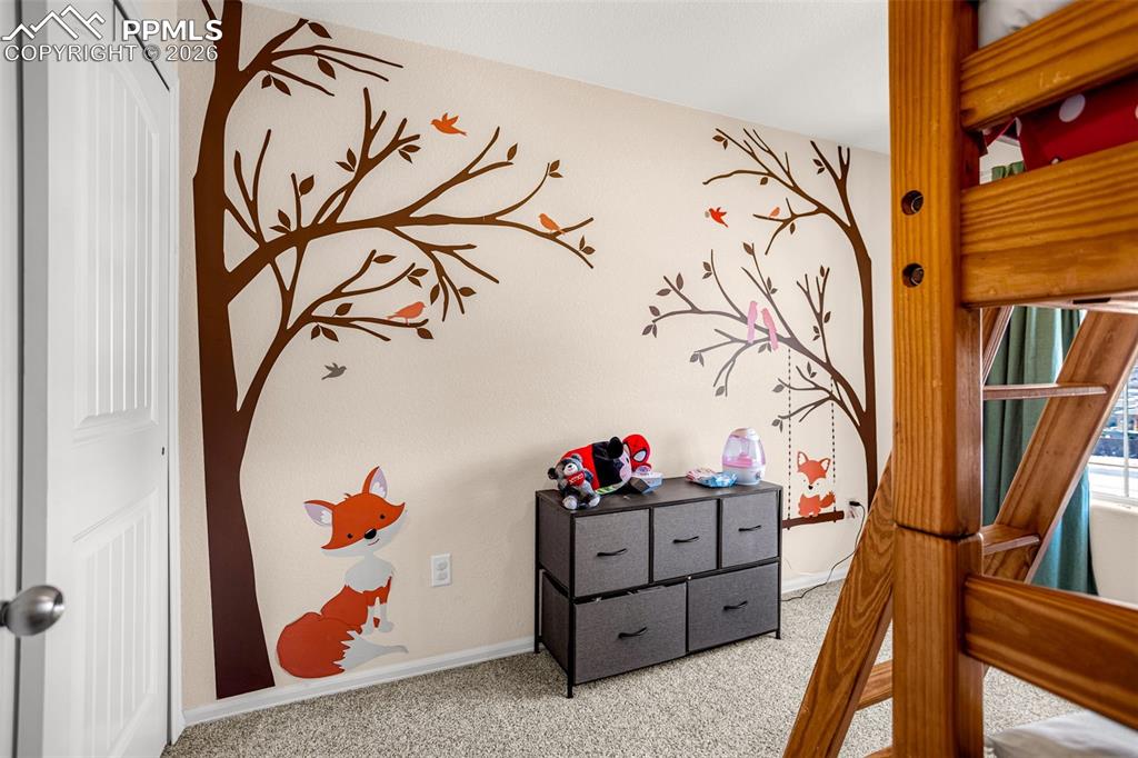 Bedroom featuring light carpet and baseboards
