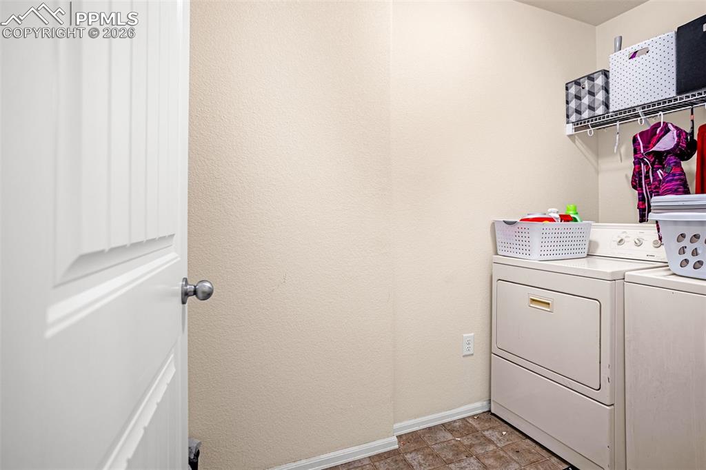 Laundry room with baseboards and separate washer and dryer