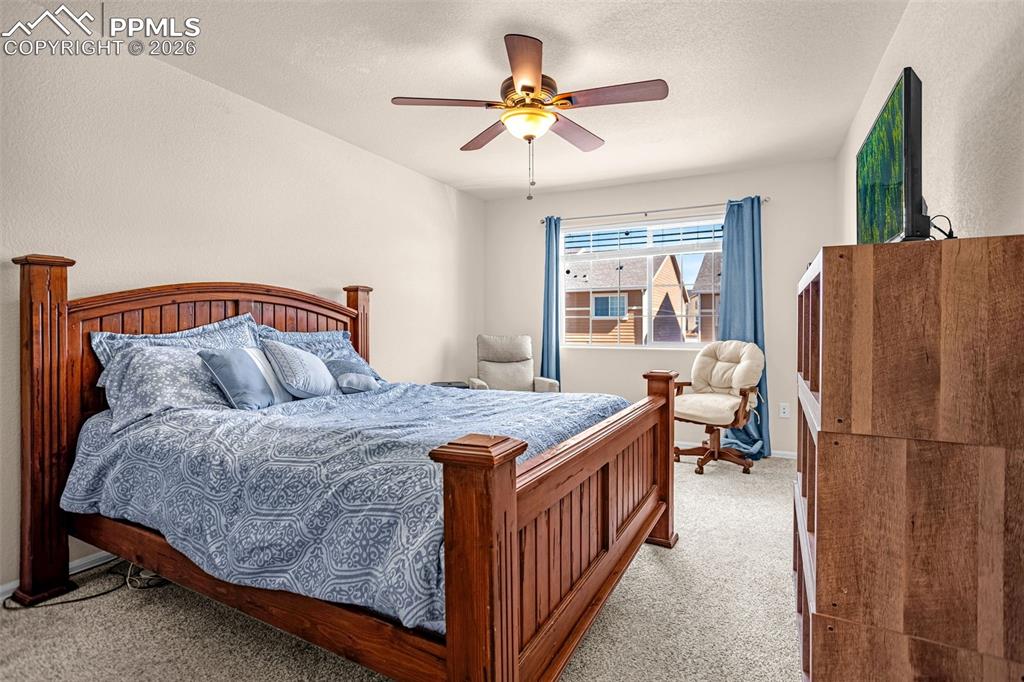 Bedroom featuring ceiling fan, carpet flooring, and a textured ceiling