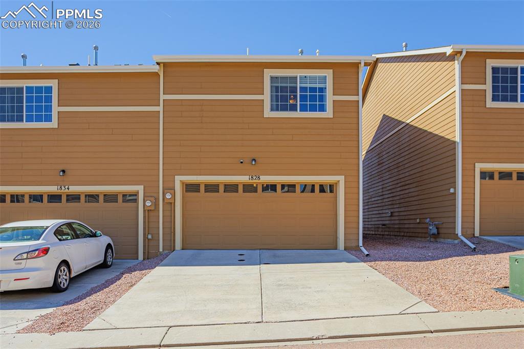 View of front of property with concrete driveway and an attached garage