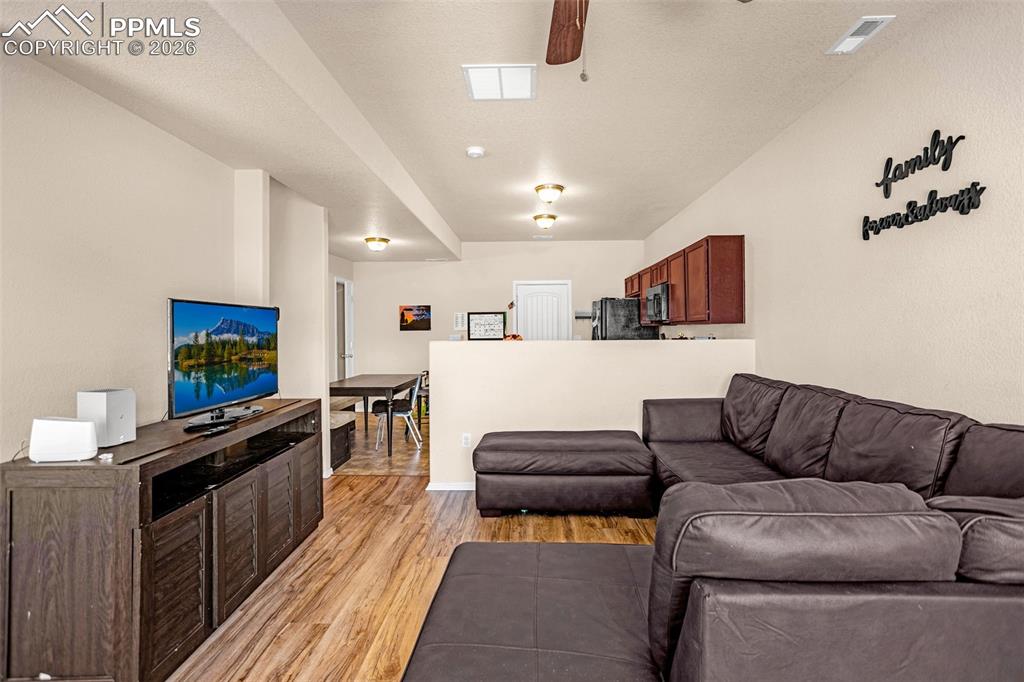 Living room with light wood-type flooring and ceiling fan