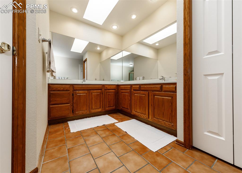 Master bathroom featuring a walk-in closet with dual vanity sinks. Comfortable and spacious.