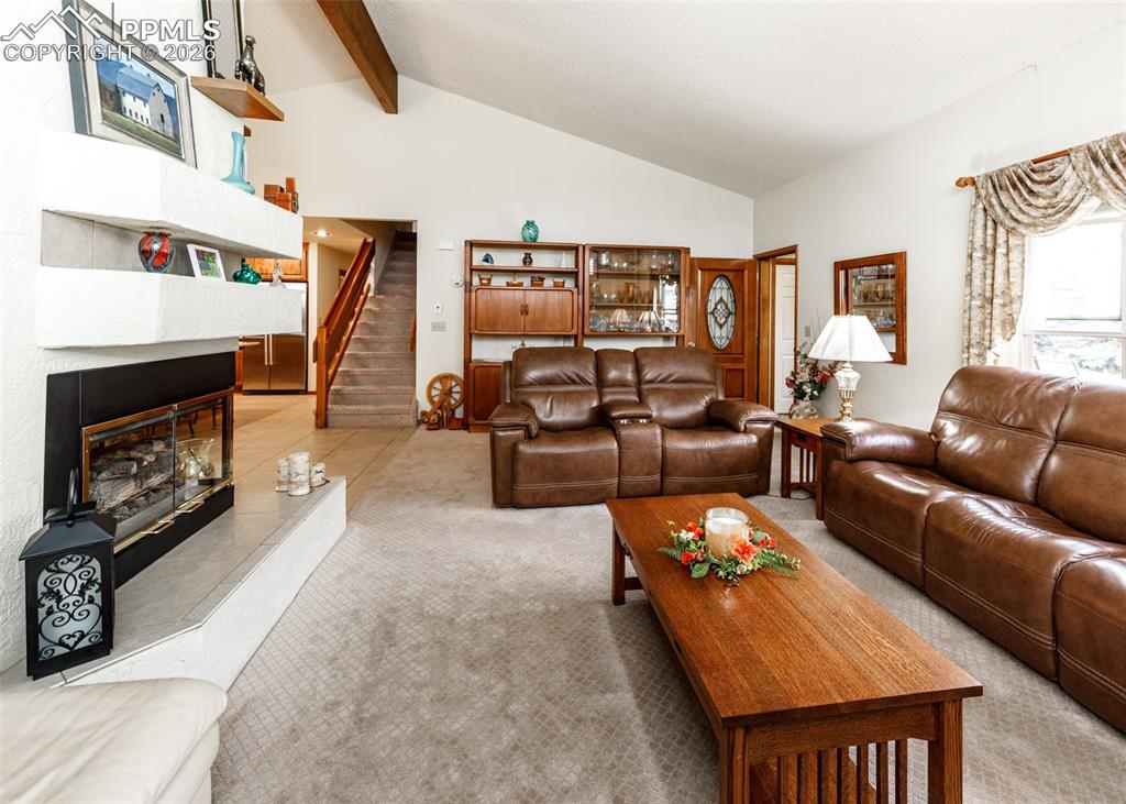 Spacious family room boasting abundant natural light through large windows and a cozy ambiance provided by a functional gas fireplace, perfect for relaxation and entertainment.