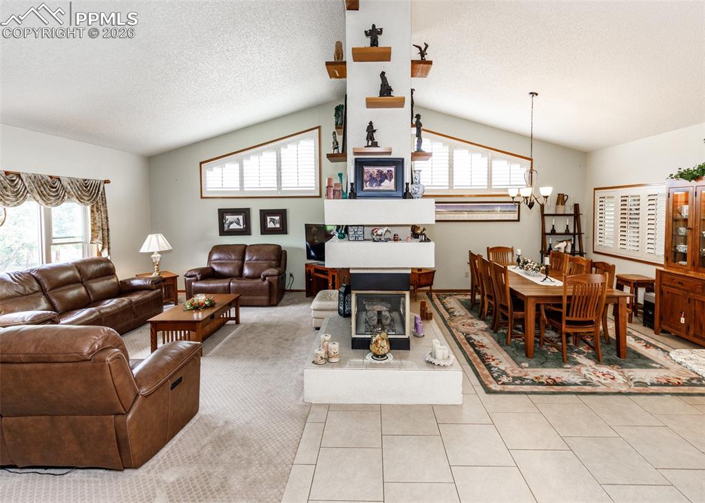 This inviting space combines a generously sized family room and dining area, expertly linked by beautifully crafted, custom-built shelving that not only enhances the flow between the two zones but also adds a touch of sophistication and functionality. The focal point of the room is a warm and inviting gas fireplace, perfect for creating a cozy ambiance, while the expansive, strategically placed windows brighten the entire area with an abundance of natural light, creating a bright, and welcoming atmosphere.