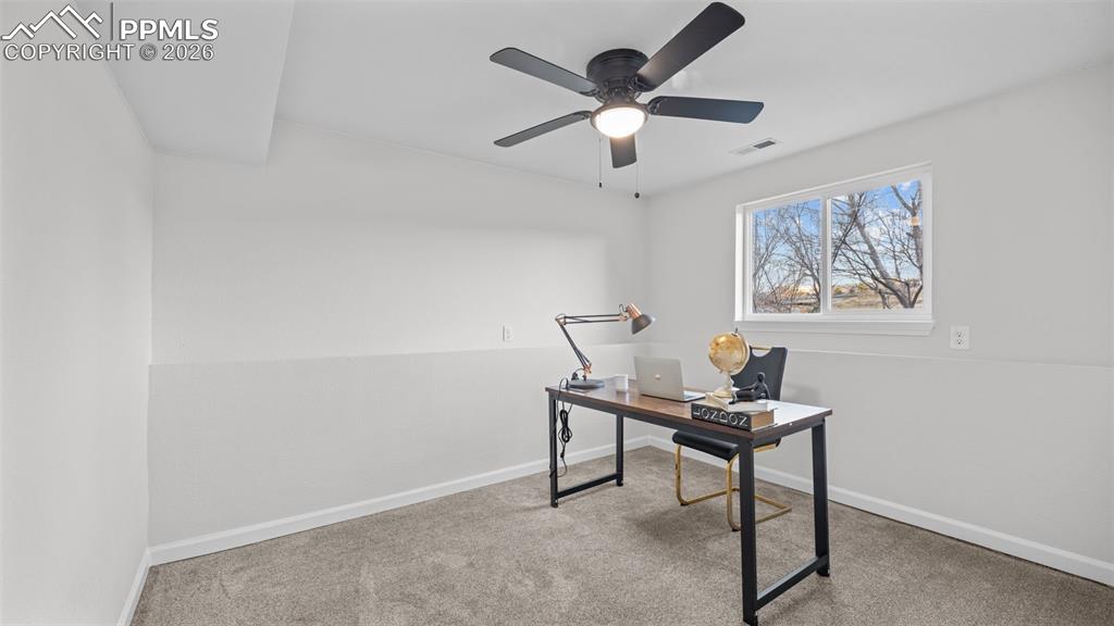 Home office featuring carpet floors and a ceiling fan