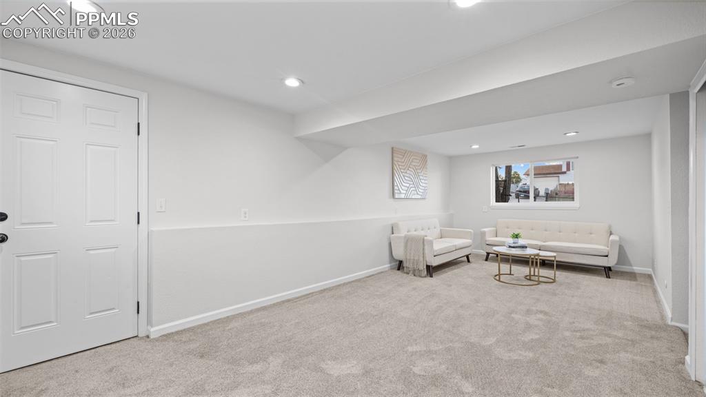 Living area featuring light colored carpet and recessed lighting