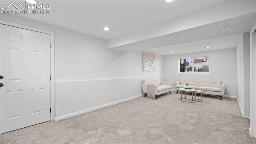 Sitting room with light colored carpet and recessed lighting