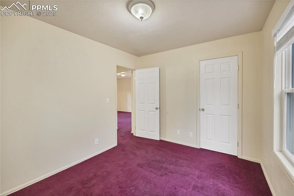 Unfurnished bedroom with carpet flooring and multiple windows