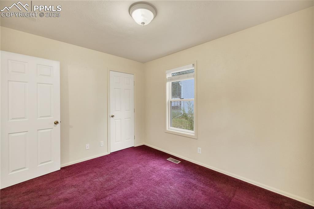 Unfurnished bedroom featuring carpet and baseboards