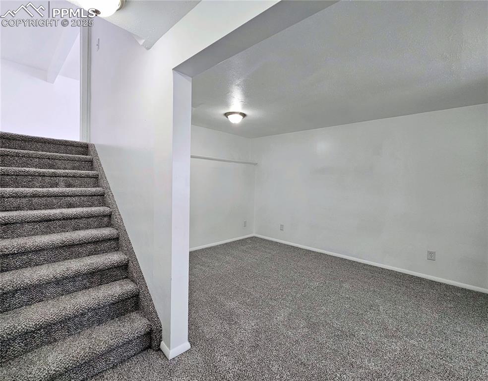 Basement with carpet flooring and stairway