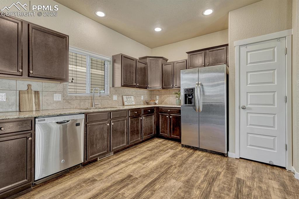 Kitchen features granite counters, stainless steel appliances, and pantry
