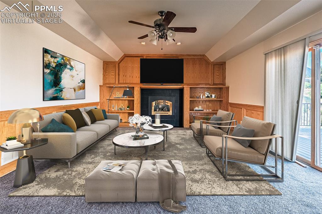 Virtually Staged
Family area featuring wainscoting, fireplace, carpet floors, built in shelves, and ceiling fan