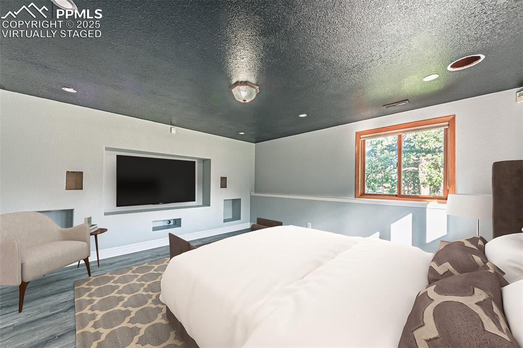 Virtually Staged
Bedroom with wood finished floors, a textured ceiling, and recessed lighting