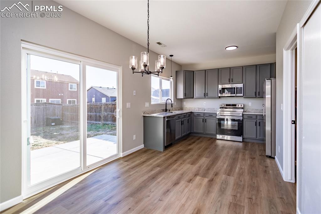 Open kitchen with lovely granite and gleaming new appliance, huge sink overlooking the back yard.