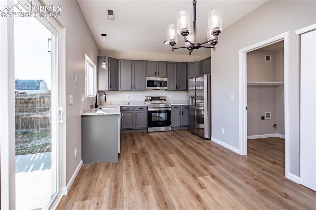 Notice the beautiful light fixtures through, LVP flooring, and the laundry room to the right.