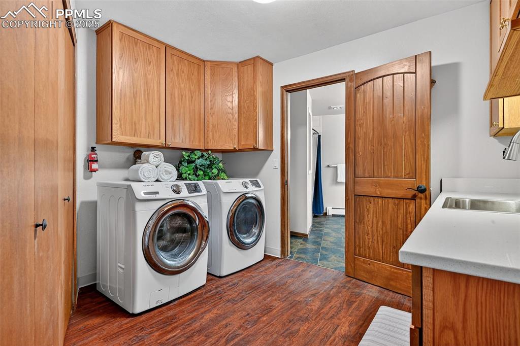 Huge laundry room with upper and lower cabinets, sink and folding counters!