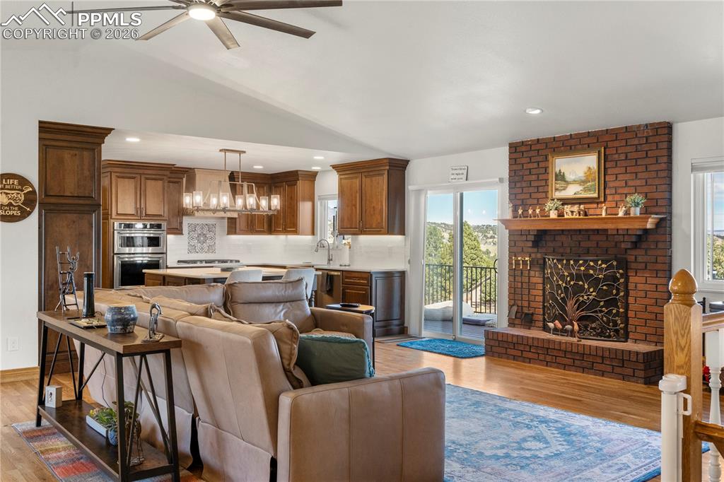 Living room with vaulted ceilings, hardwood flooring, wood burning fireplace and stunning views! 