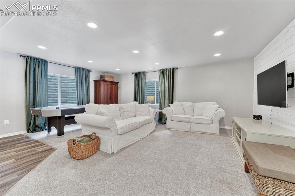 Living room with light colored carpet, recessed lighting, baseboards, and a wealth of natural light