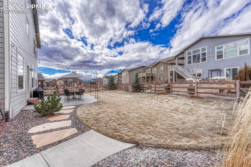 View of yard with a residential view, a fenced backyard, and a patio area