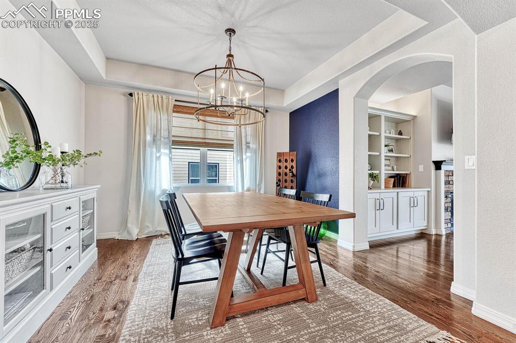 Dining space with built in features, baseboards, and wood finished floors