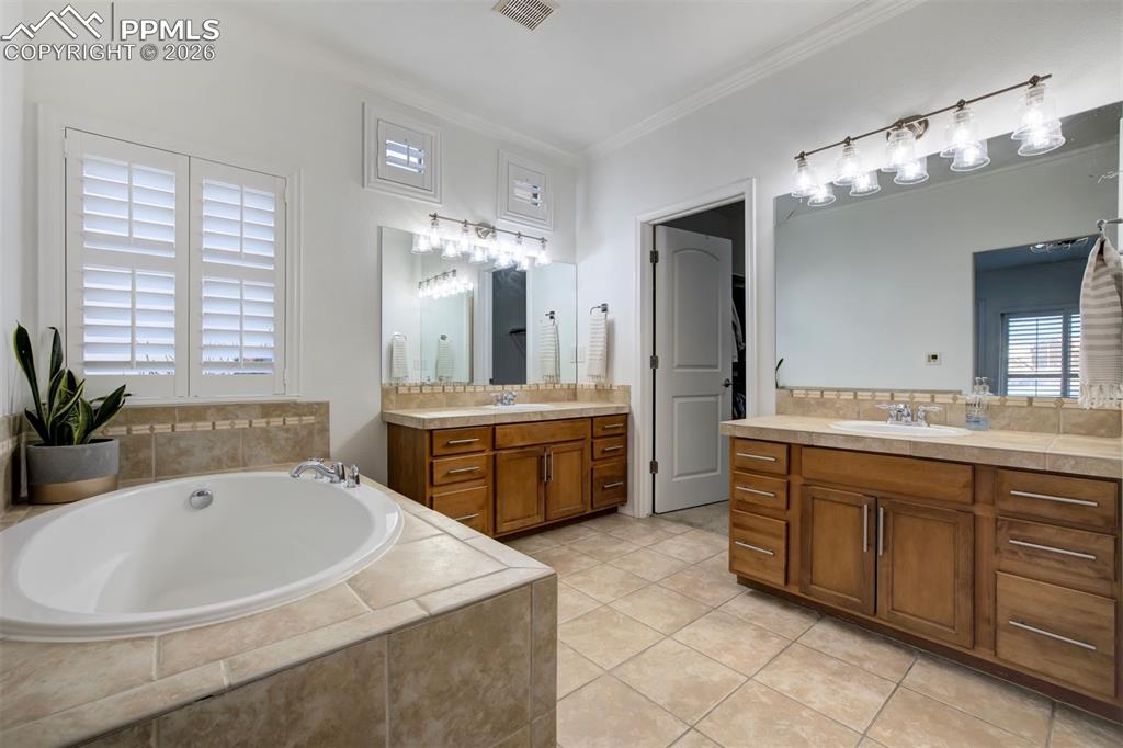 Large soaking tub with double vanity and entrance to the walk-in closet