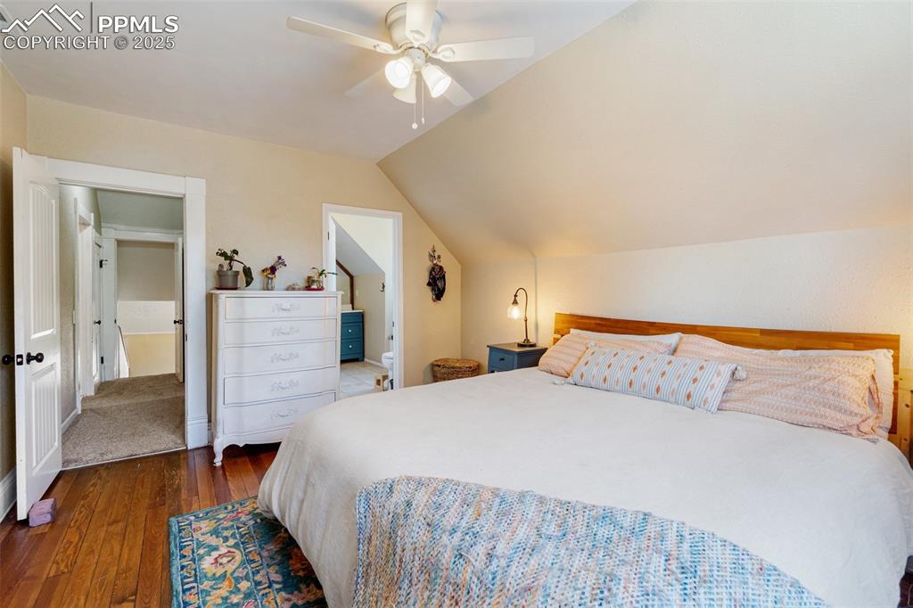 Bedroom featuring dark wood finished floors, lofted ceiling, and a ceiling fan