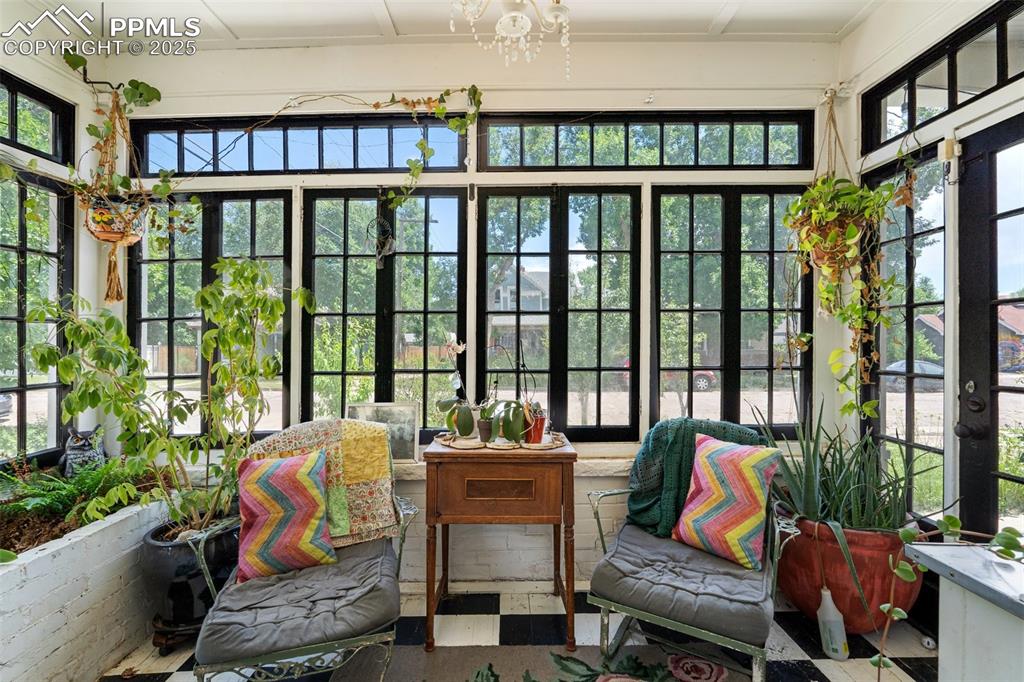 Sunroom / solarium featuring plenty of natural light and a chandelier