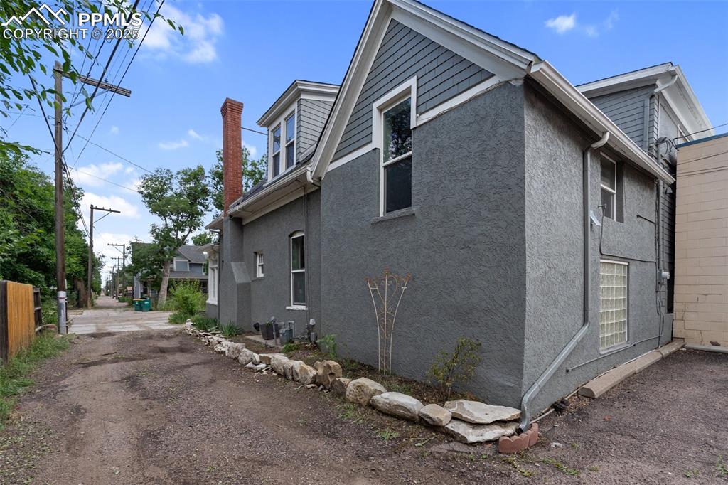 View of side of property with stucco siding and a chimney