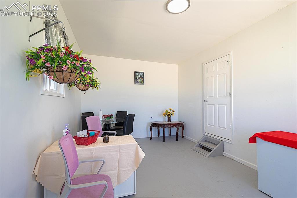 Home office with concrete flooring and baseboards