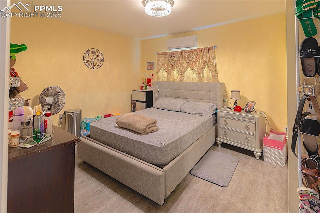 Bedroom featuring a wall mounted air conditioner and wood finished floors