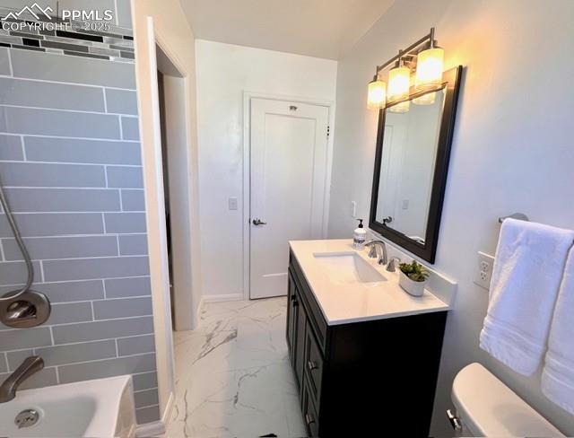 Full bathroom with light marble finish flooring, shower / washtub combination, and vanity