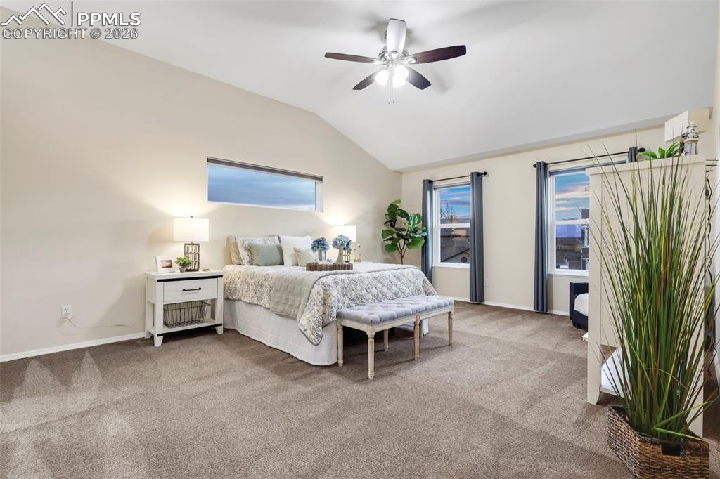 Bedroom featuring carpet floors, vaulted ceiling, and ceiling fan