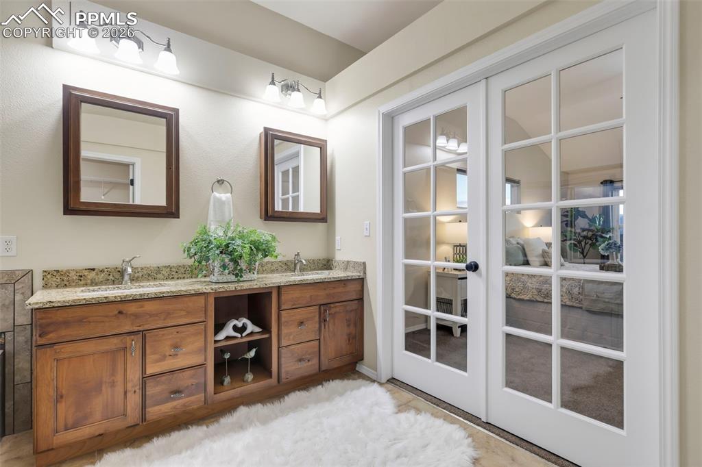 Full bath featuring double vanity and french doors