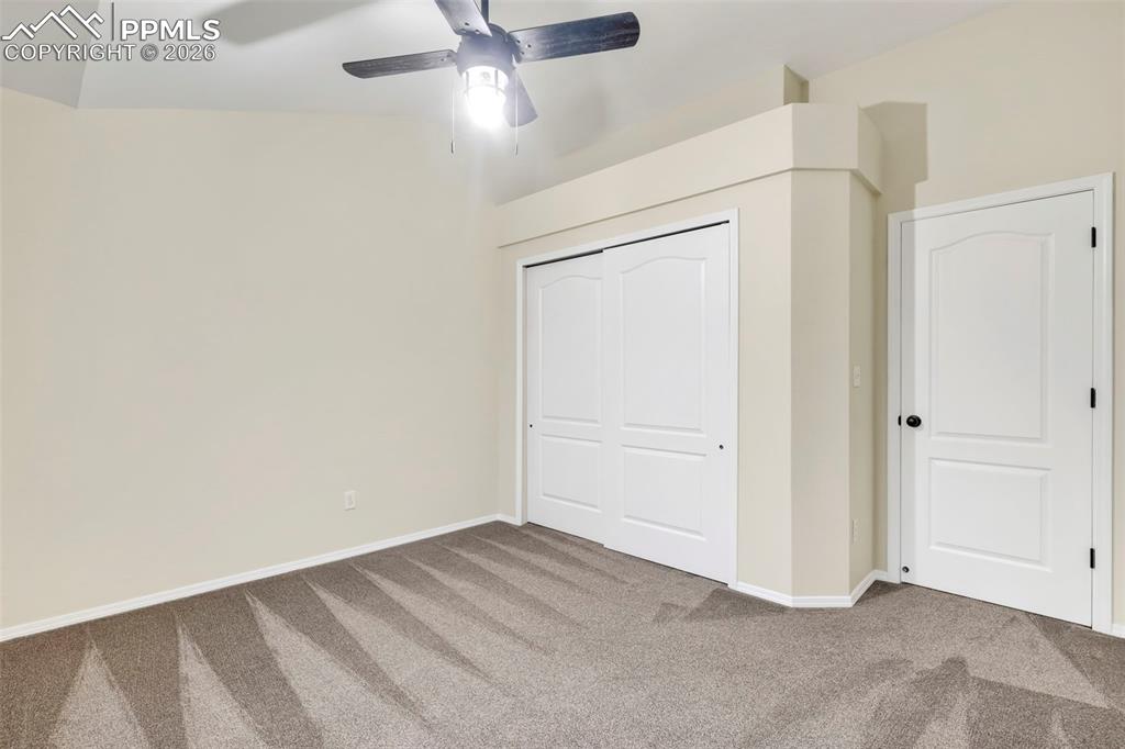 Unfurnished bedroom with carpet, a closet, and ceiling fan
