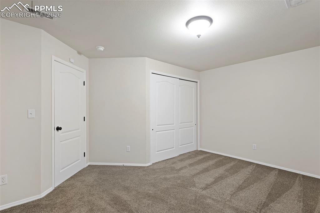 Unfurnished bedroom featuring carpet and a closet