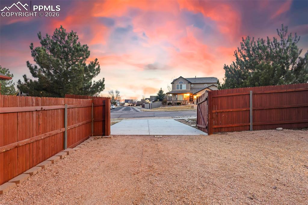 View of yard at dusk with gate and RV Parking
