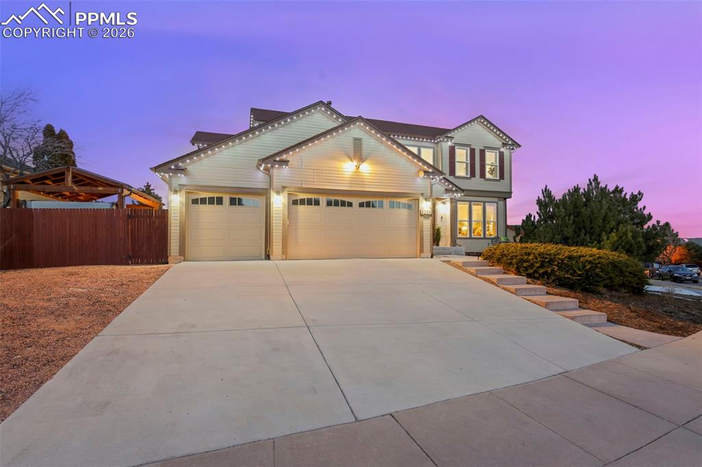 View of front of home with an attached garage and large driveway