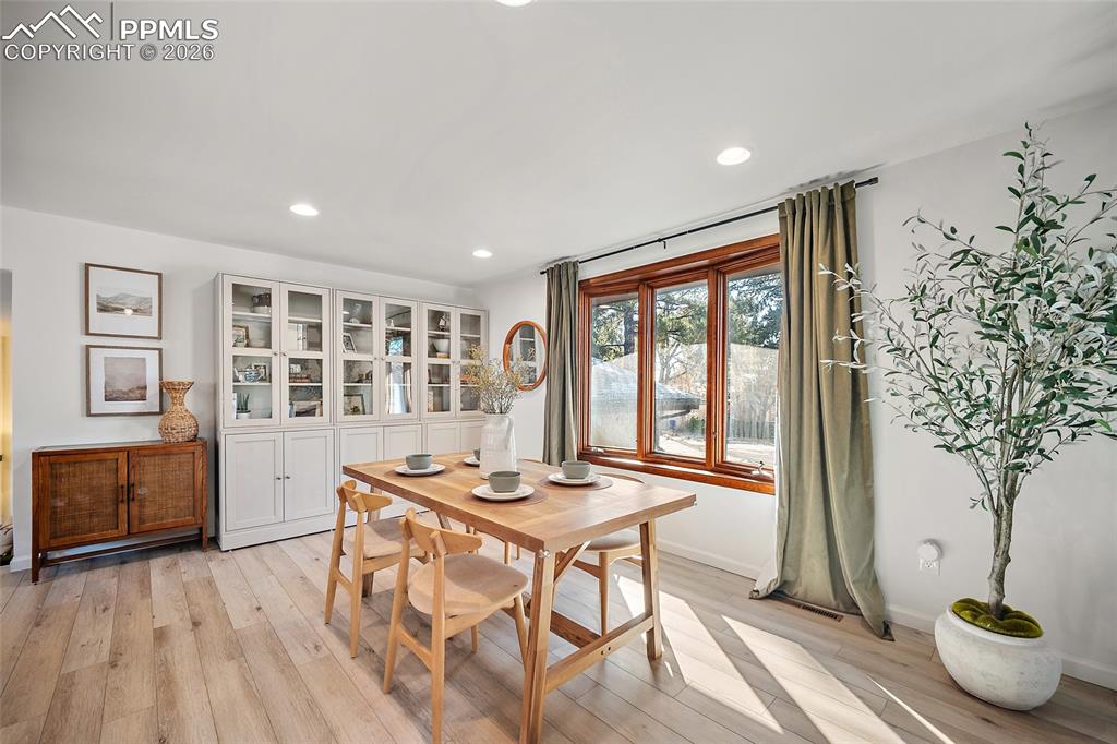 Dining space featuring light wood finished floors and recessed lighting, original wood trim bay window.