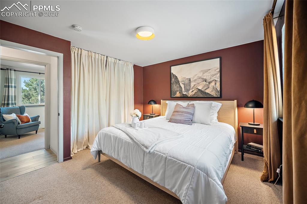 Primary bedroom with light colored carpet