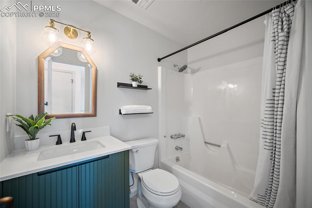 Upper level full bath featuring vanity and shower / bathtub combination with curtain
