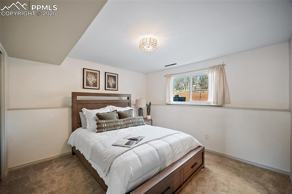 Basement garden level bedroom with carpet flooring and adjoining bathroom