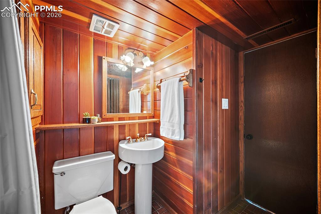 Bathroom with wood walls and wooden ceiling