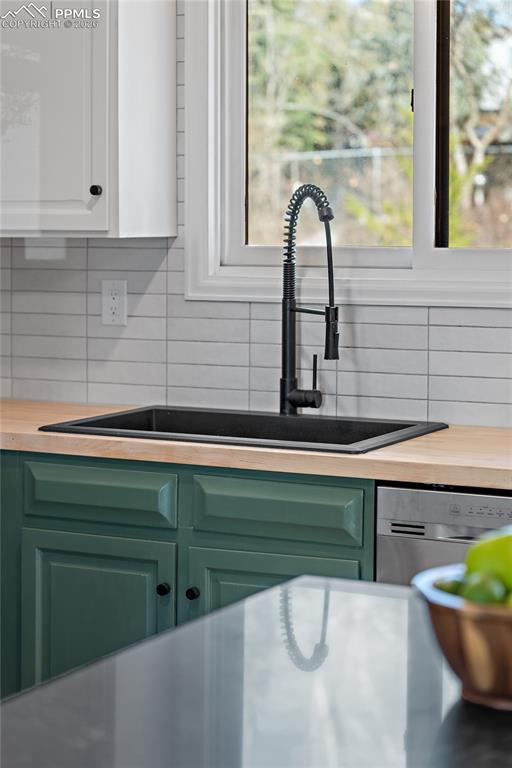 Kitchen view of green cabinets, dishwasher, and white cabinetry