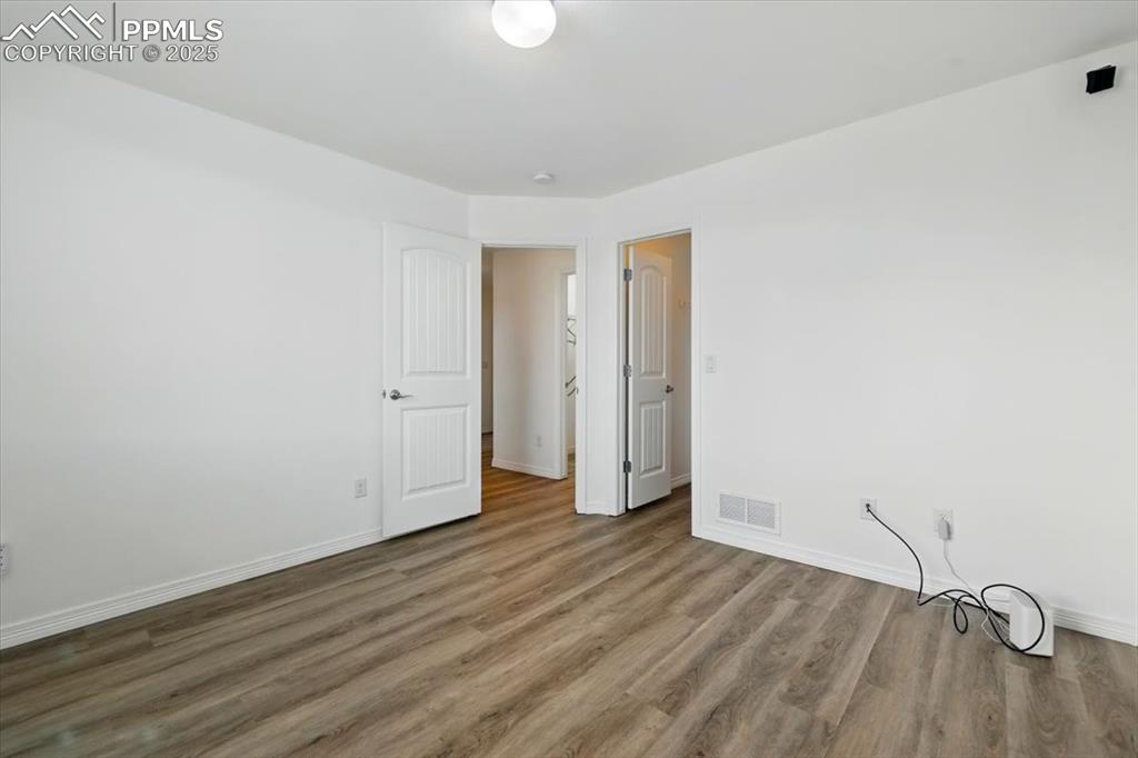Unfurnished room featuring wood finished floors and baseboards