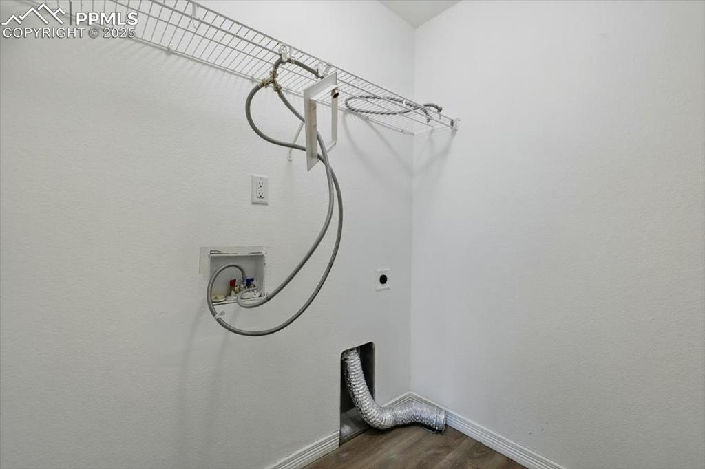 Laundry area featuring dark wood finished floors, hookup for an electric dryer, baseboards, and washer hookup