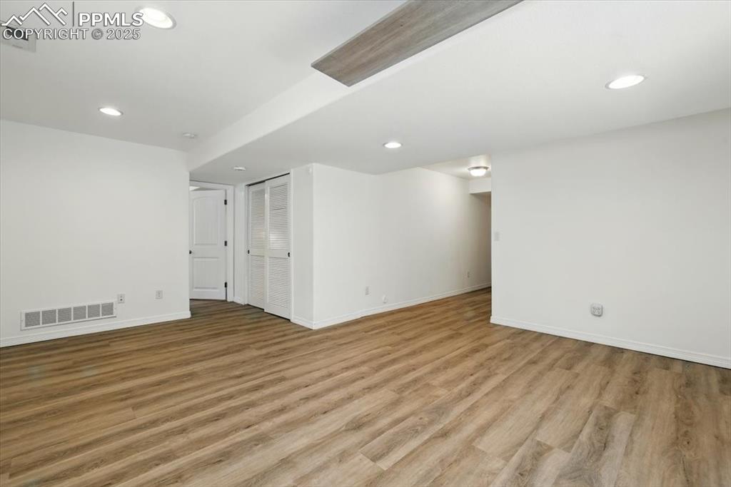Empty room with baseboards, light wood-style flooring, and recessed lighting