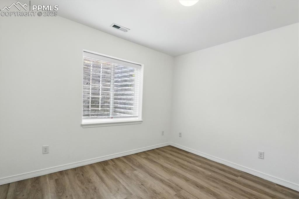 Unfurnished room featuring wood finished floors and baseboards