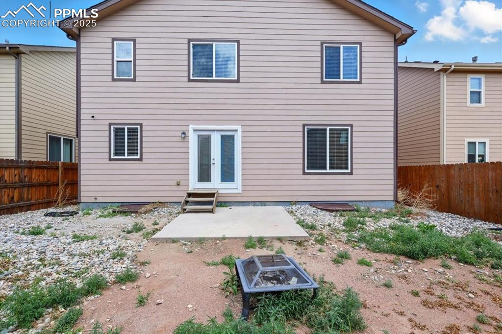 Back of house featuring a fenced backyard, a patio, french doors, and entry steps
