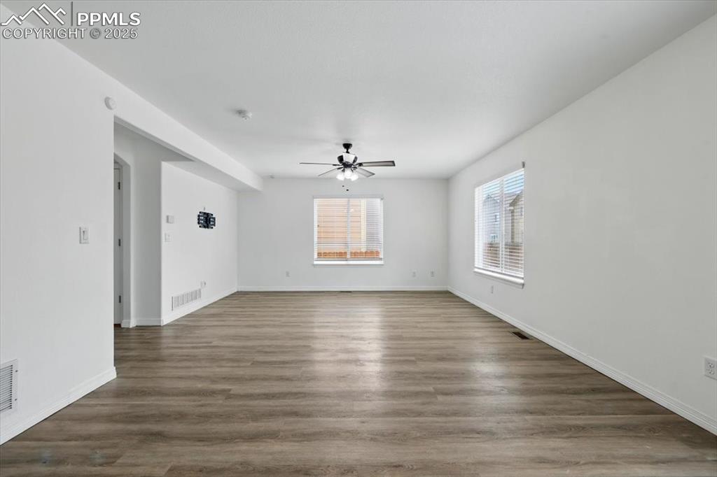 Family or living room with a ceiling fan, baseboards, and wood finished floors