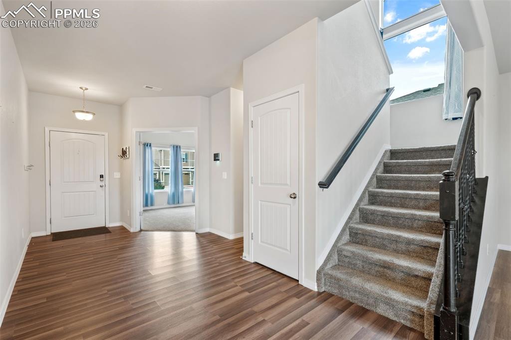 Entryway with stairway and dark wood-type flooring